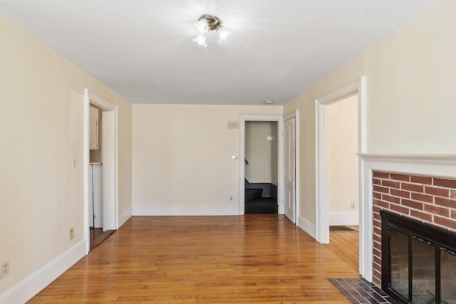 301 S Main, Haverhill, MA 01835 - unfurnished living room with stairway, baseboards, a fireplace, and light wood-style flooring