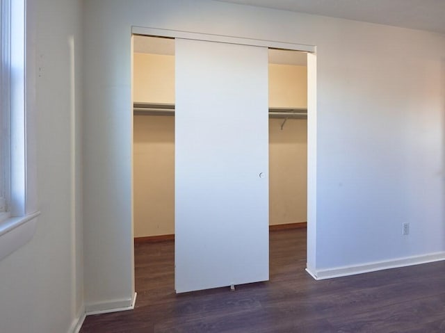 unfurnished bedroom featuring a closet and dark hardwood / wood-style floors