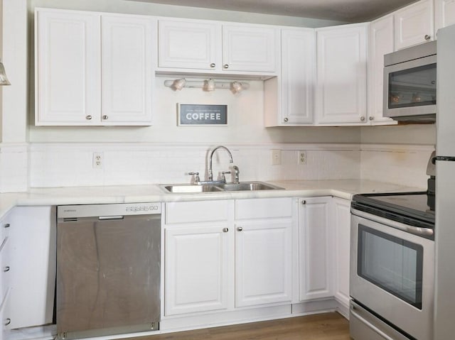 kitchen featuring sink, white cabinetry, dark hardwood / wood-style floors, and stainless steel appliances