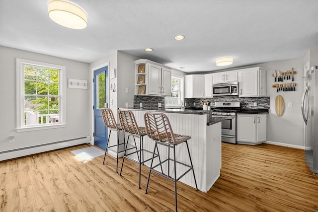 1137 Ferry St, Marshfield, MA 02050 - kitchen featuring appliances with stainless steel finishes, open shelves, a peninsula, plenty of natural light, and recessed lighting