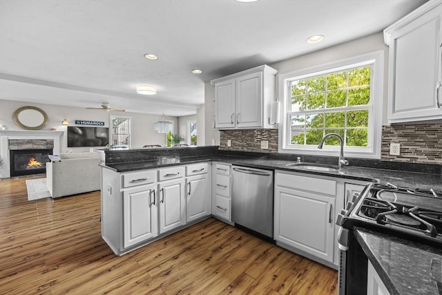 1137 Ferry St, Marshfield, MA 02050 - kitchen featuring dishwasher, a sink, gas stove, a peninsula, and decorative backsplash