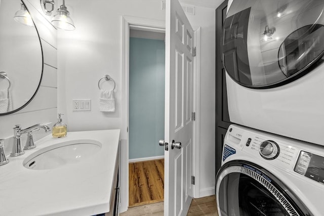 1137 Ferry St, Marshfield, MA 02050 - washroom featuring stacked washer / drying machine, a sink, wood finished floors, and baseboards