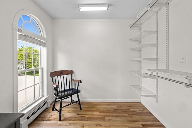 1137 Ferry St, Marshfield, MA 02050 - living area with a baseboard heating unit, light wood-type flooring, and baseboards