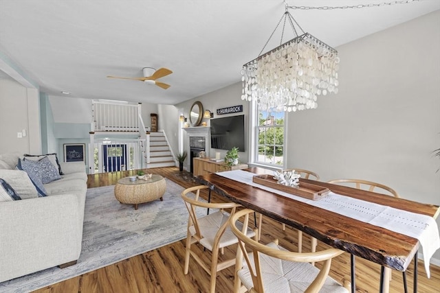 1137 Ferry St, Marshfield, MA 02050 - dining space featuring a fireplace, wood finished floors, stairs, and a ceiling fan
