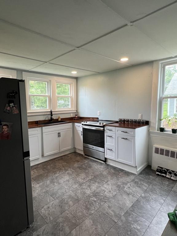 34 Old Bernardston Rd, Northfield, MA 01360 - kitchen with stainless steel appliances, a sink, radiator heating unit, white cabinetry, and recessed lighting