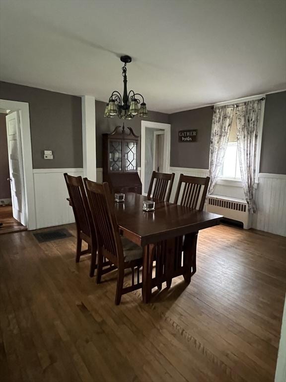 34 Old Bernardston Rd, Northfield, MA 01360 - dining area with radiator heating unit, a wainscoted wall, a chandelier, and dark wood-type flooring