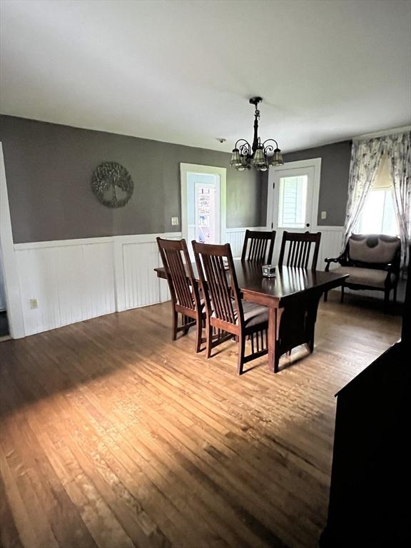34 Old Bernardston Rd, Northfield, MA 01360 - dining area featuring wood finished floors, wainscoting, and a chandelier