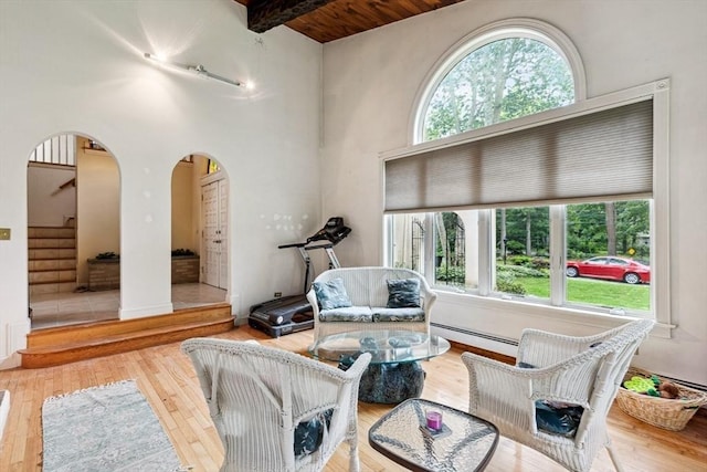 2 Orchard St, Berkley, MA 02779 - living room featuring arched walkways, a baseboard heating unit, hardwood / wood-style floors, stairway, and a high ceiling
