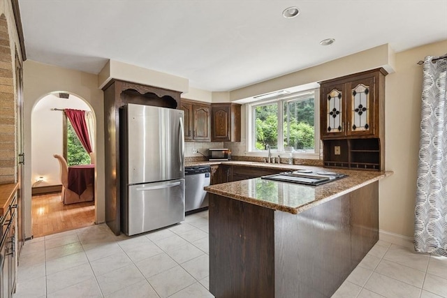 2 Orchard St, Berkley, MA 02779 - kitchen featuring appliances with stainless steel finishes, a peninsula, stone countertops, decorative backsplash, and light tile patterned floors