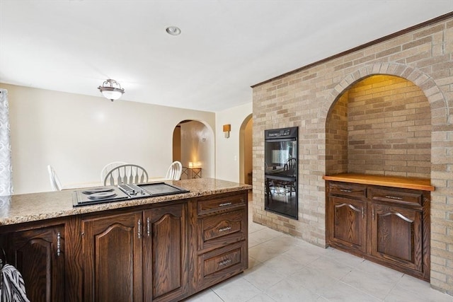 2 Orchard St, Berkley, MA 02779 - kitchen featuring black appliances, brick wall, light countertops, light tile patterned floors, and arched walkways