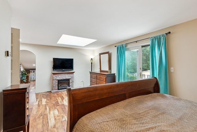 2 Orchard St, Berkley, MA 02779 - bedroom with a skylight, a stone fireplace, wood finished floors, and arched walkways