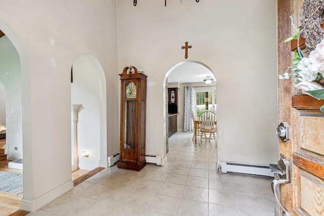 2 Orchard St, Berkley, MA 02779 - entrance foyer with baseboard heating, a towering ceiling, arched walkways, light tile patterned floors, and baseboards