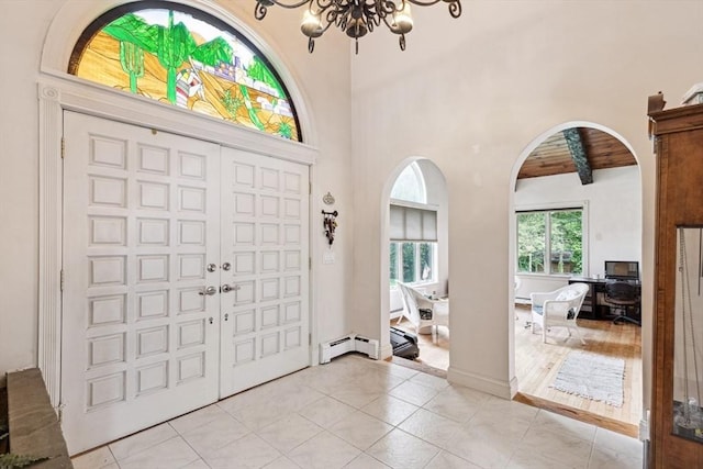 2 Orchard St, Berkley, MA 02779 - foyer featuring baseboard heating, arched walkways, light tile patterned flooring, beam ceiling, and a chandelier