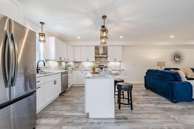 438 Granite St, Worcester, MA 01604 - kitchen with appliances with stainless steel finishes, wall chimney range hood, open floor plan, a breakfast bar, and light stone countertops