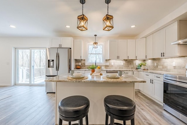 438 Granite St, Worcester, MA 01604 - kitchen with appliances with stainless steel finishes, light wood-style floors, a breakfast bar, white cabinetry, and recessed lighting