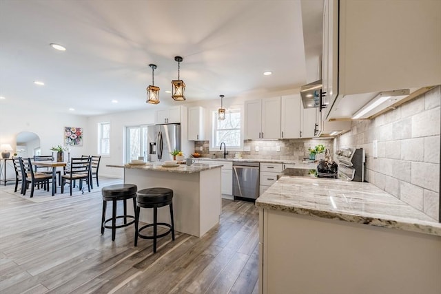 438 Granite St, Worcester, MA 01604 - kitchen with stainless steel appliances, a kitchen breakfast bar, light wood-style floors, a kitchen island, and backsplash