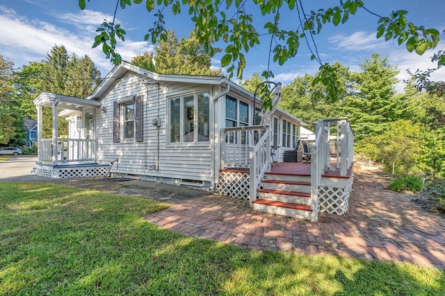 view of front facade featuring a wooden deck and a front yard