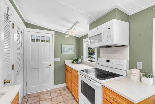 kitchen featuring white appliances, tasteful backsplash, and lofted ceiling