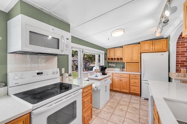 kitchen with white appliances, light tile patterned floors, backsplash, lofted ceiling, and track lighting