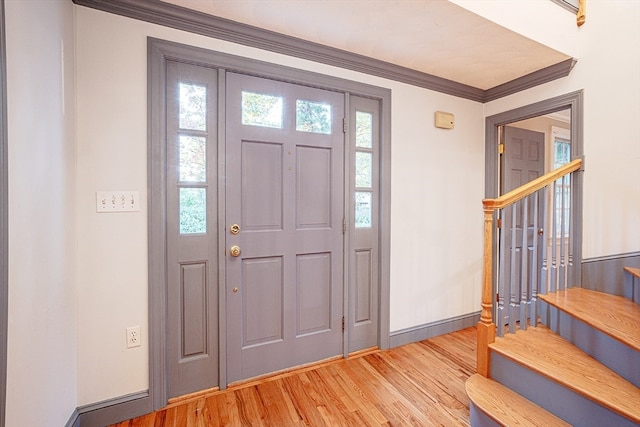 entrance foyer with hardwood / wood-style flooring and crown molding