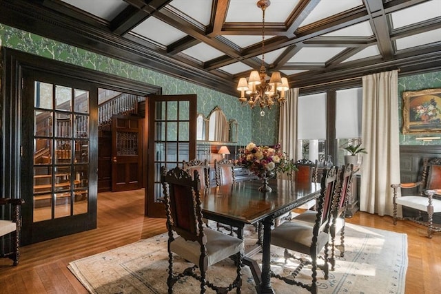 dining room with coffered ceiling, wallpapered walls, beamed ceiling, and a chandelier