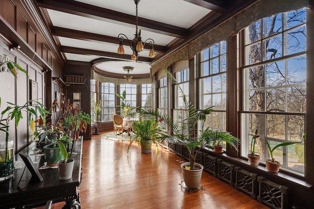 sunroom with a notable chandelier and beamed ceiling