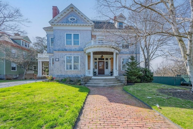 view of front of home with a front lawn and a chimney