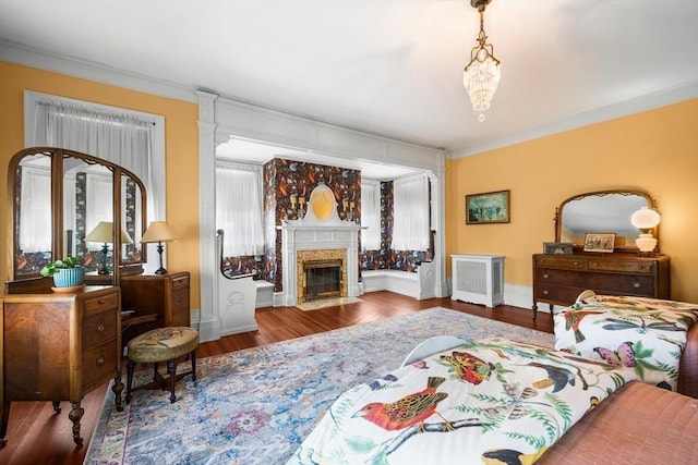 bedroom featuring ornamental molding, baseboards, wood finished floors, and a high end fireplace
