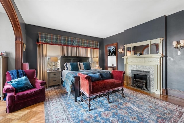 bedroom featuring a fireplace with flush hearth and baseboards