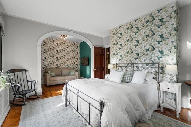 bedroom with ornamental molding, arched walkways, and wallpapered walls