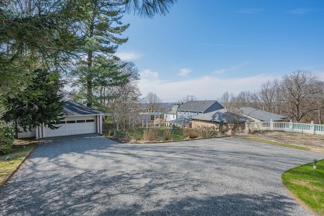 view of front of home with a residential view, driveway, and fence