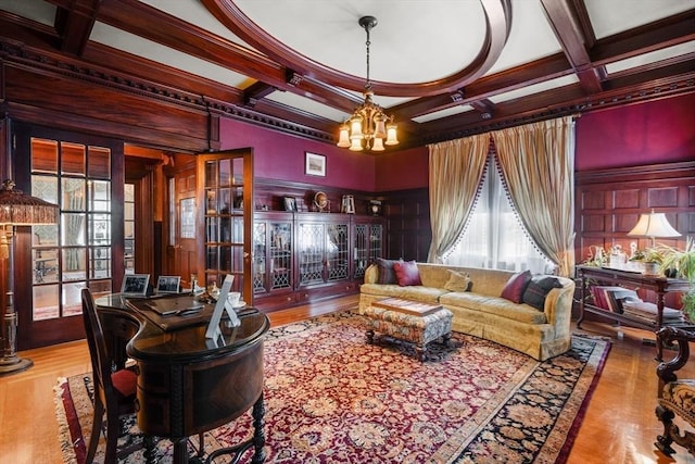 living area featuring plenty of natural light, an inviting chandelier, beam ceiling, and coffered ceiling