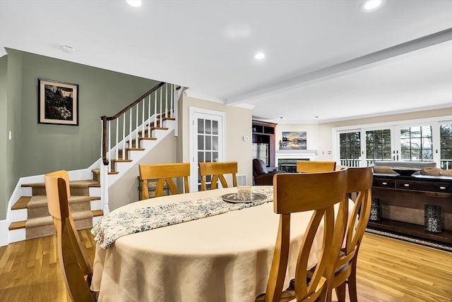 dining room with beamed ceiling and light hardwood / wood-style floors