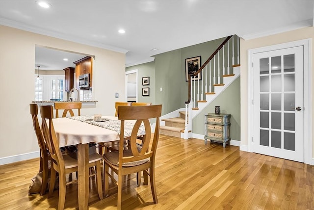 dining area featuring light hardwood / wood-style floors and ornamental molding