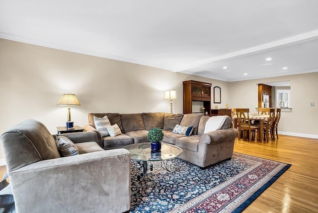 living room featuring hardwood / wood-style flooring, beam ceiling, and ornamental molding