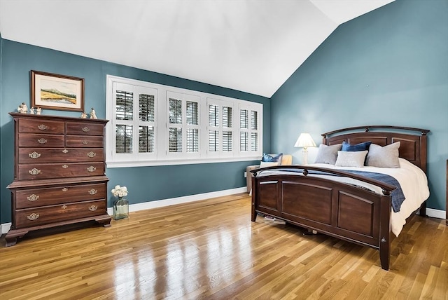 bedroom with lofted ceiling and light wood-type flooring