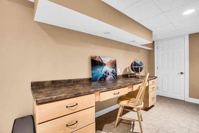 office area featuring a drop ceiling and built in desk