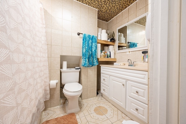 bathroom featuring decorative backsplash, vanity, toilet, and tile walls