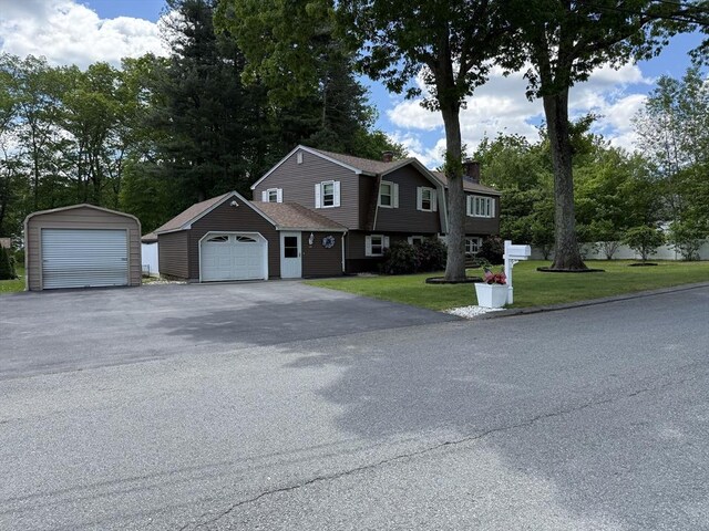 75 I St, Dracut, MA 01826 - view of front facade with an outdoor structure, a front yard, and a garage