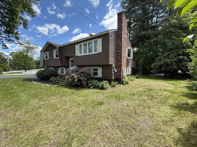 75 I St, Dracut, MA 01826 - view of front of home with a chimney and a front yard