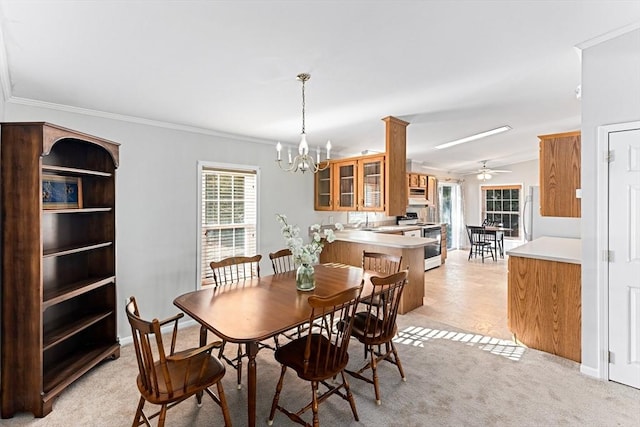 carpeted dining room featuring crown molding and ceiling fan with notable chandelier