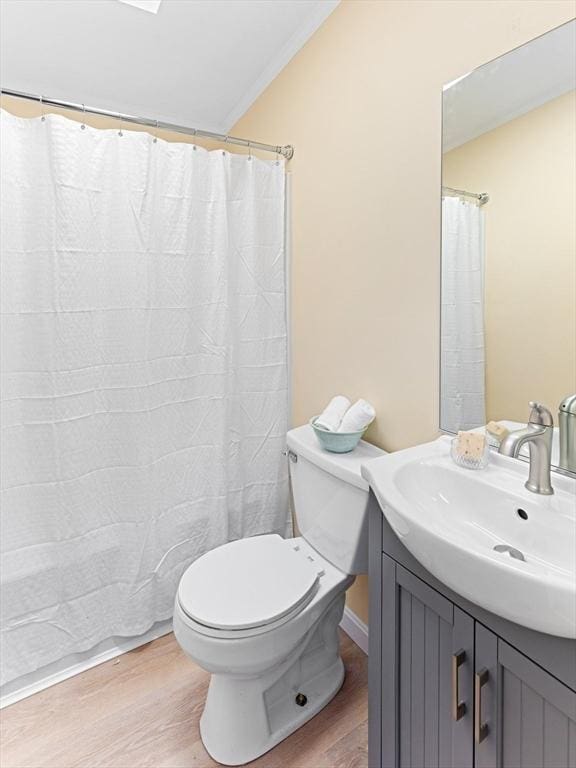 bathroom with crown molding, hardwood / wood-style floors, vanity, and toilet