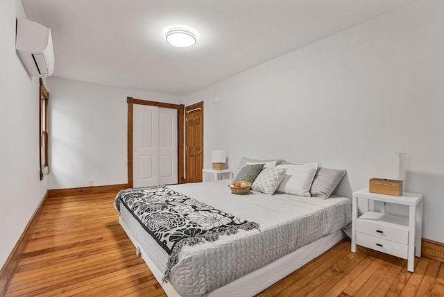 38 Main St, Acton, MA 01720 - bedroom with light wood-style flooring, a wall mounted AC, and baseboards