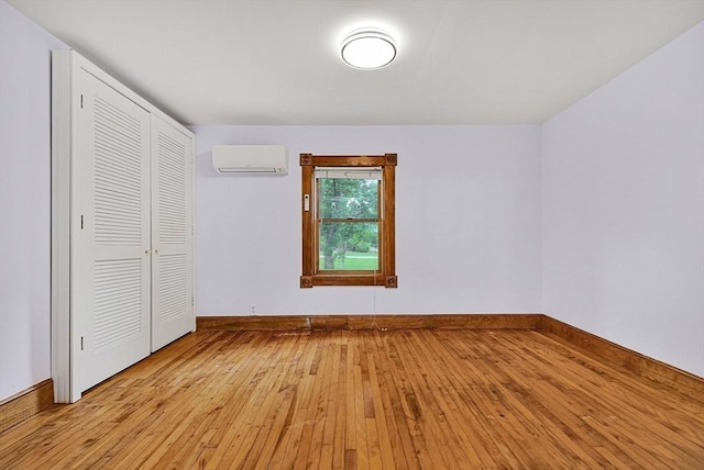 38 Main St, Acton, MA 01720 - unfurnished bedroom with a wall mounted AC, light wood finished floors, a closet, and baseboards