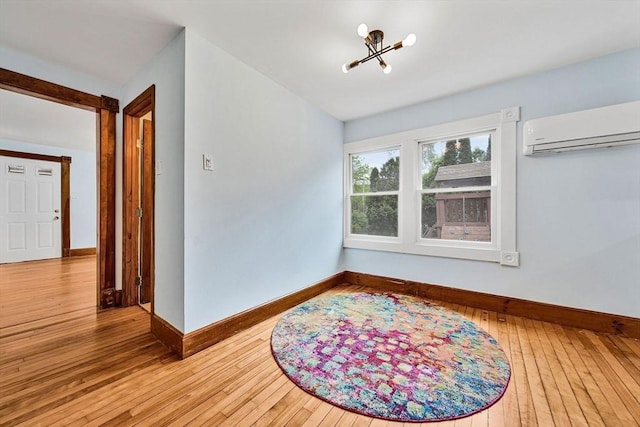 38 Main St, Acton, MA 01720 - empty room featuring a wall mounted air conditioner, baseboards, a chandelier, and hardwood / wood-style flooring