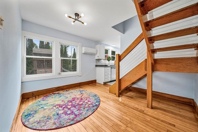 38 Main St, Acton, MA 01720 - living area featuring a wall mounted air conditioner, a chandelier, light wood-type flooring, and baseboards