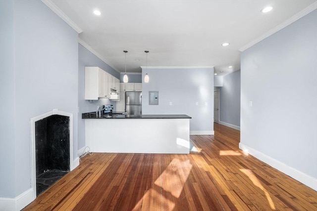 kitchen featuring white cabinets, stainless steel appliances, kitchen peninsula, and pendant lighting