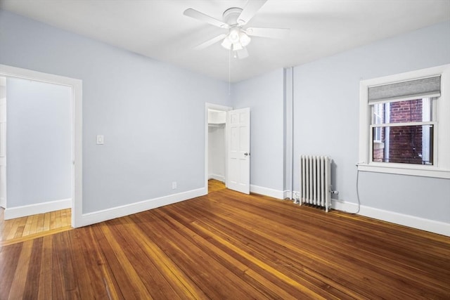 unfurnished bedroom with wood-type flooring, radiator heating unit, and ceiling fan