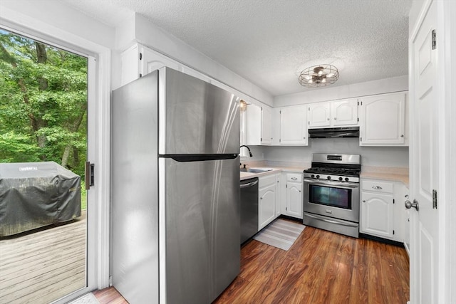 2 Colonial Dr Unit 2, Norton, MA 02766 - kitchen with stainless steel appliances, under cabinet range hood, light countertops, white cabinets, and a textured ceiling