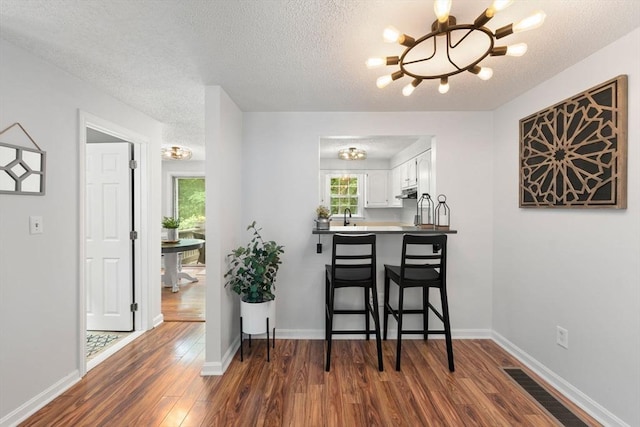 2 Colonial Dr Unit 2, Norton, MA 02766 - dining area featuring a chandelier, dark wood-style flooring, and a textured ceiling